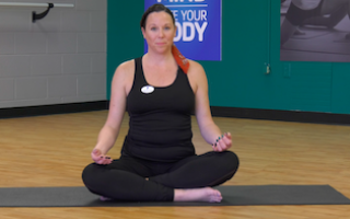YMCA yoga instructor sitting on yoga mat
