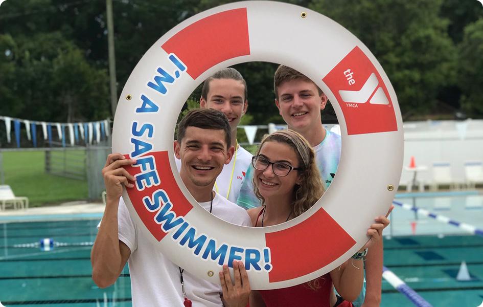 lifeguards holding up safe swimmer sign
