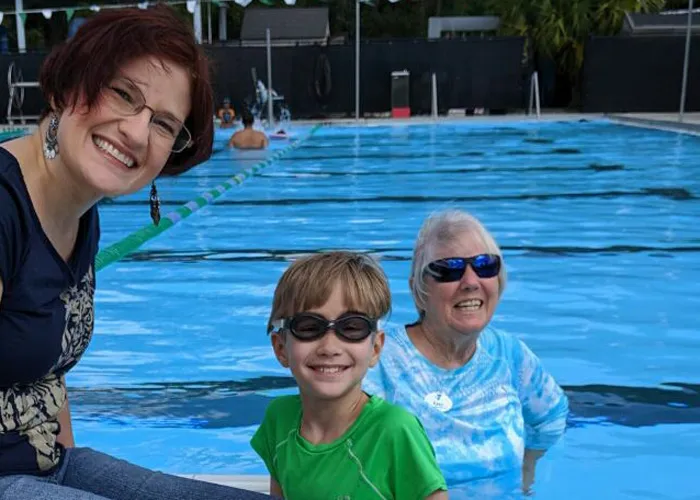 Mother and son in pool with swim instructor
