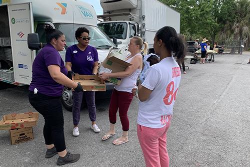 Tampa YMCA Veggie Van staff dispersing packages of produce