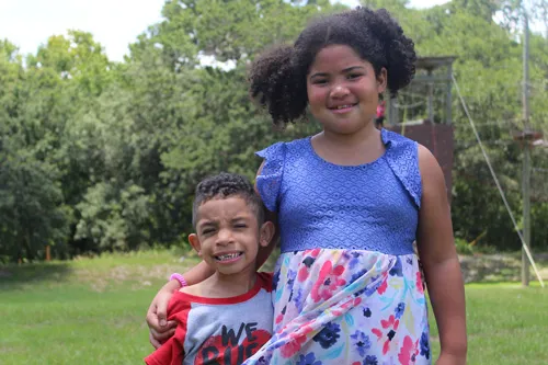 sibilings stand side by side at ymca camp cristina outdoor summer camp