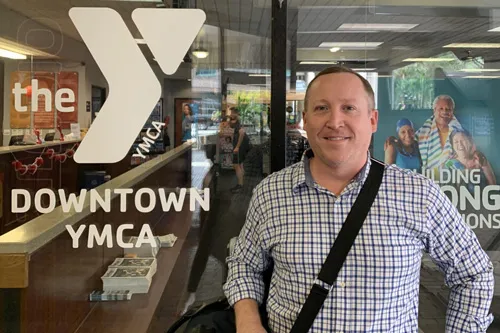 man standing in front of downtown tampa ymca