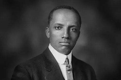 black and white headshot of Carter Woodson with gray background