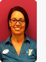 headshot of female personal trainer wearing blue YMCA polo red background