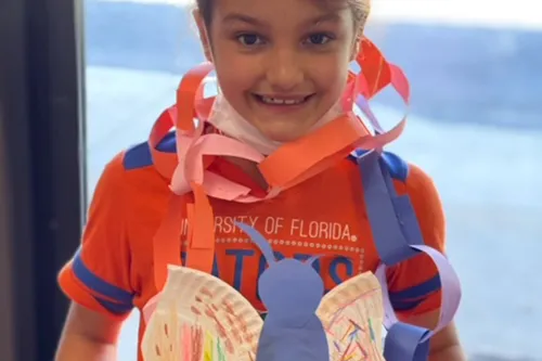 Young girl wearing handmade crafts from summer camp