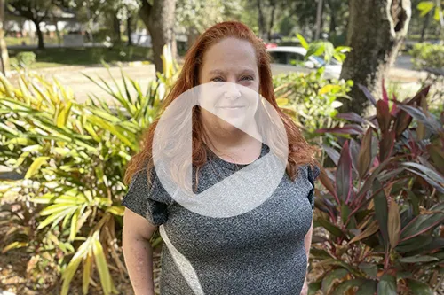 April Grant stands proud outside in a tropical landscape.