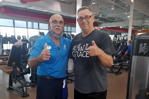 ymca trainer and veteran posing with thumbs up on the wellness floor