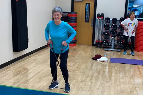 member in pilates class, using resistance band for core exercise