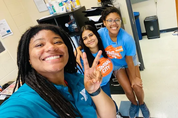 YMCA advisor with two teen leaders smiling for a selfie at the Y.