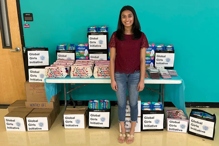 Founder Aanya Patel with dozens of donated menstrual hygiene products at the Y for her organization Global Girls Initiative.