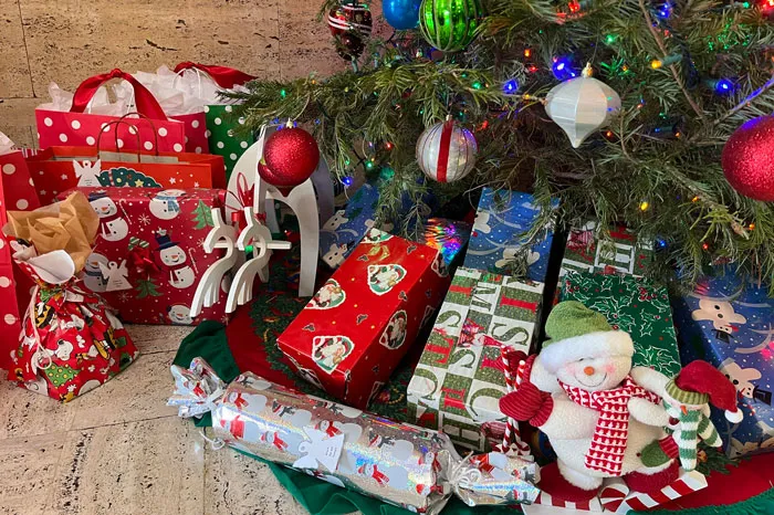 Closeup photo of wrapped gifts under a Christmas tree. 