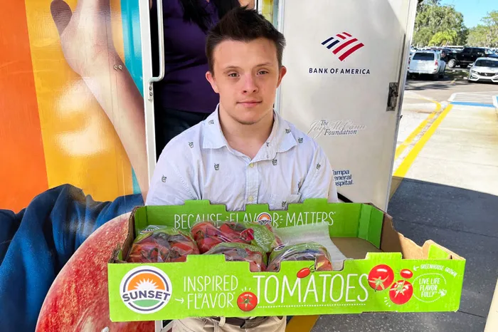 A Tampa Y Veggie Van volunteer named Robert helps unload produce at a distribution location in his community.