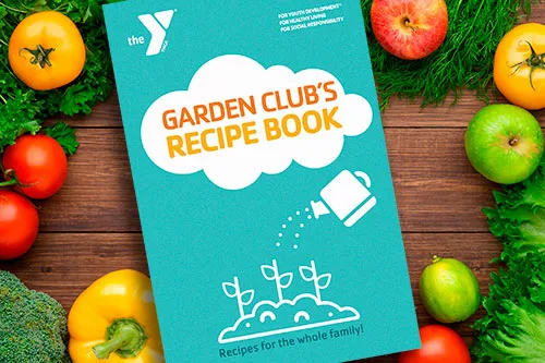 Tampa YMCA Sulphur Springs graphic of the Garden Club's Recipe Book. The book is teal with the title in a white cloud; Y logo in white and white outline graphic with text Recipes for the whole family! The background and border is tomatoes, bell peppers and leafy greens on wood plank table.