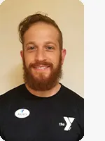 headshot of male personal trainer wearing black YMCA shirt beige background