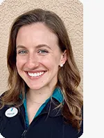 headshot of female personal trainer wearing black YMCA polo beige background