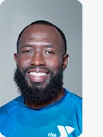 headshot of male personal trainer wearing blue YMCA shirt gray background