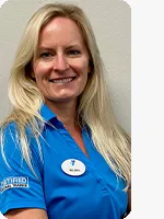 headshot of female personal trainer wearing blue YMCA polo gray background