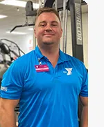 headshot of male personal trainer wearing light blue polo with Y logo in the gym
