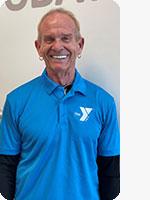 headshot of male personal trainer wearing blue YMCA polo white background