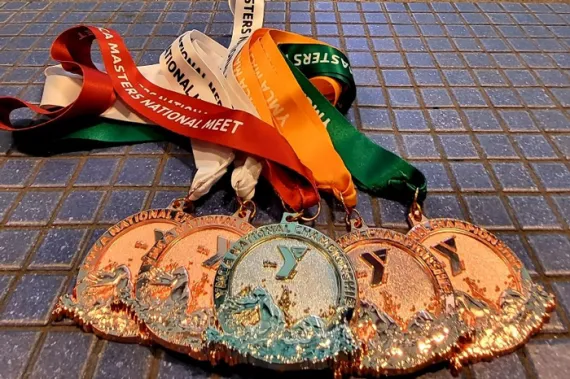 five swimming with YMCA logo on pool deck
