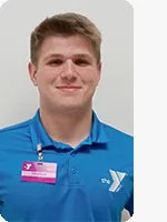 headshot of male personal trainer wearing blue YMCA polo with white Y logo and beige background