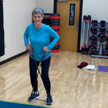member in pilates class, using resistance band for core exercise
