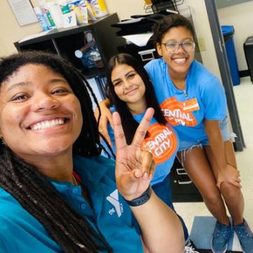 YMCA advisor with two teen leaders smiling for a selfie at the Y.