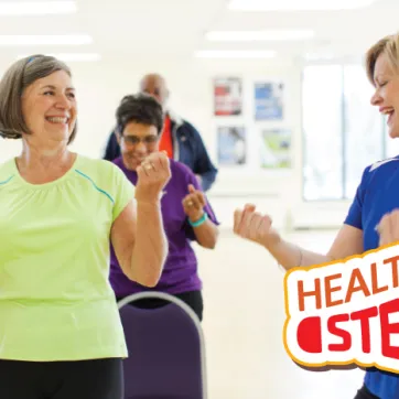 Woman exercising with YMCA staff member. Text reads healthy steps (logo)
